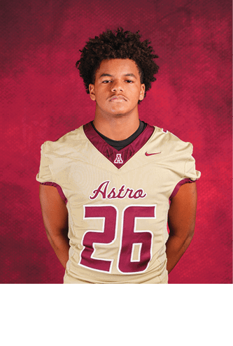 Person with short dreadlocks wearing a beige and maroon football jersey with the number 27 and the word Astro on the front against a red textured background. Description generated by AI
