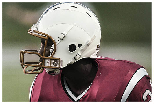 A football player wearing a helmet and a red jersey with the number 24. Description generated by AI