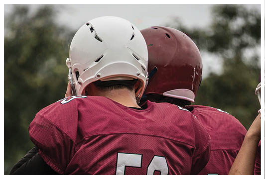 A man wearing a red and white jersey with the number 53 on it. Description generated by AI