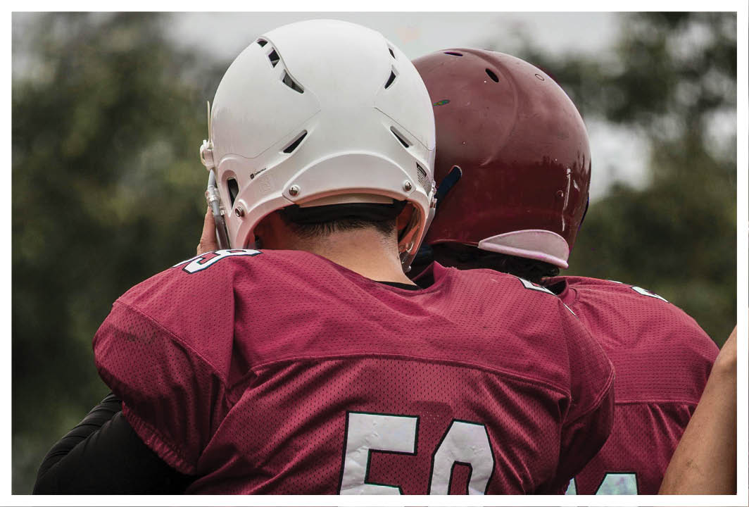A man wearing a red and white jersey with the number 53 on it. Description generated by AI