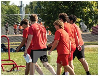 A group of football players on a field. Description generated by AI