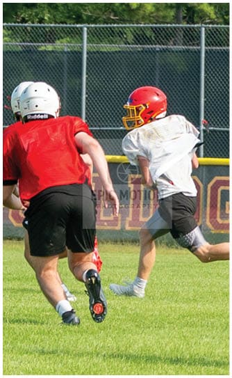 A football player catching a ball. Description generated by AI