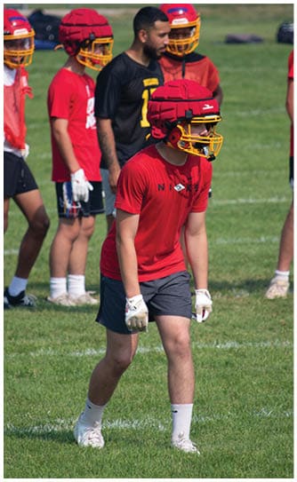 A football player catching a ball. Description generated by AI