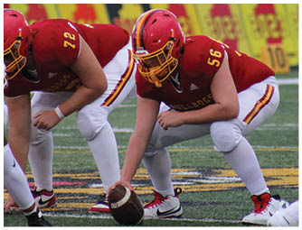 A group of football players on a field. Description generated by AI
