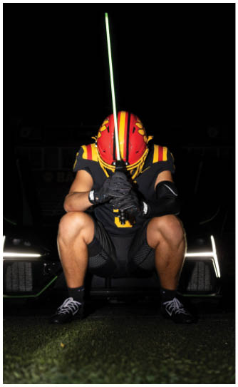 A football player catching a ball. Description generated by AI