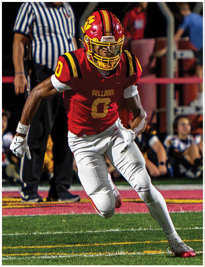 A football player wearing a blue and red jersey. Description generated by AI