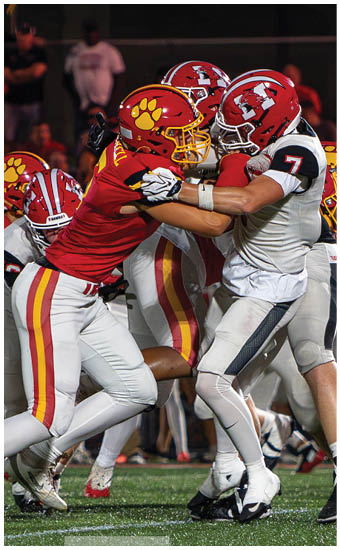 Two football players wearing blue and white uniforms. Description generated by AI