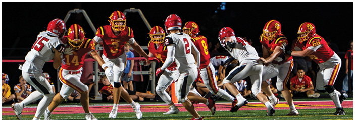 A football game is taking place on a field with players wearing blue and white uniforms. Description generated by AI