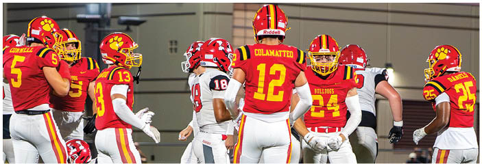 A football game is taking place on a field with players wearing blue and white uniforms. Description generated by AI