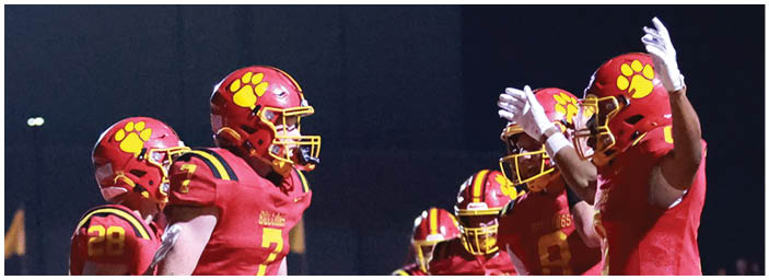 A group of football players on a field. Description generated by AI