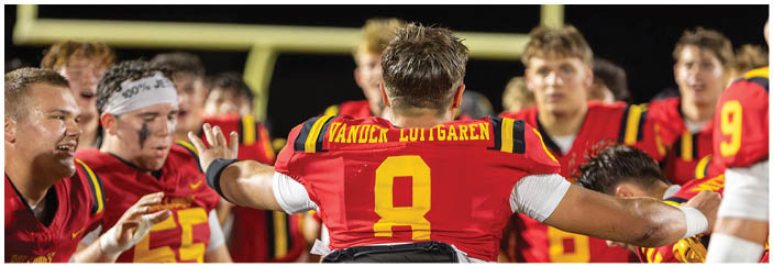 A football game is taking place on a field with players wearing blue and white uniforms. Description generated by AI