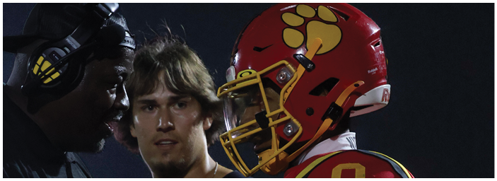 A group of football players on a field. Description generated by AI