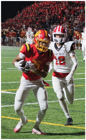Two football players wearing blue and white uniforms. Description generated by AI