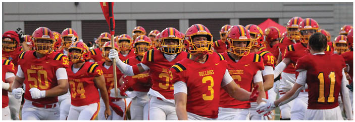 A football game is taking place on a field with players wearing blue and white uniforms. Description generated by AI