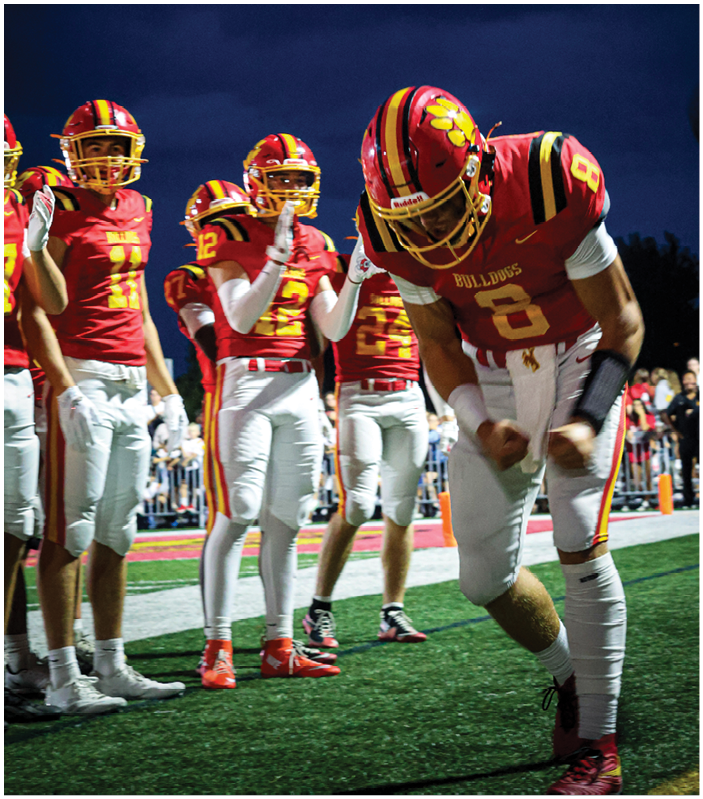 A group of football players on a field. Description generated by AI