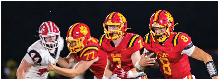 A group of football players on a field. Description generated by AI