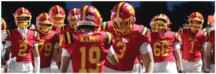 A football game is taking place on a field with players wearing blue and white uniforms. Description generated by AI