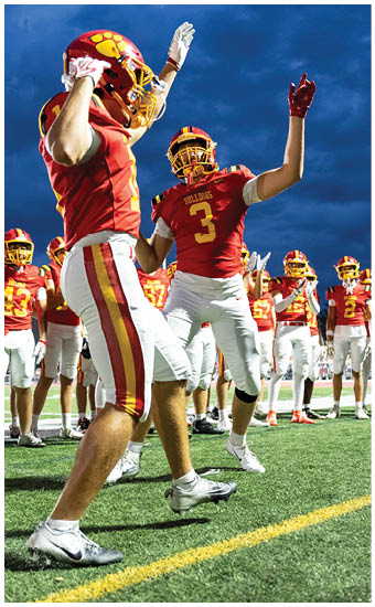 Two football players wearing blue and white uniforms. Description generated by AI