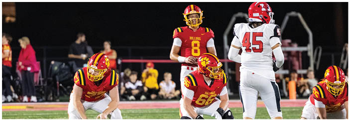 A football game is taking place on a field with players wearing blue and white uniforms. Description generated by AI