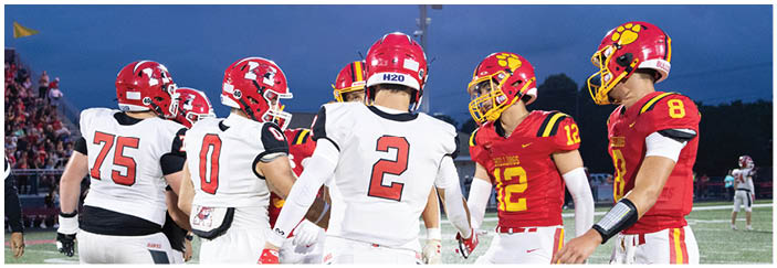 A football game is taking place on a field with players wearing blue and white uniforms. Description generated by AI