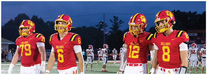 A group of football players on a field. Description generated by AI