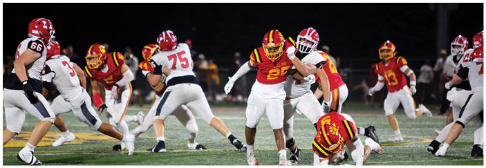 A football game is taking place on a field with players wearing blue and white uniforms. Description generated by AI