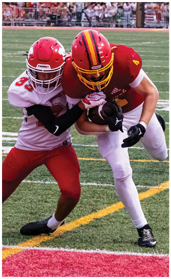 A football player catching a ball. Description generated by AI
