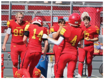 A group of football players on a field. Description generated by AI