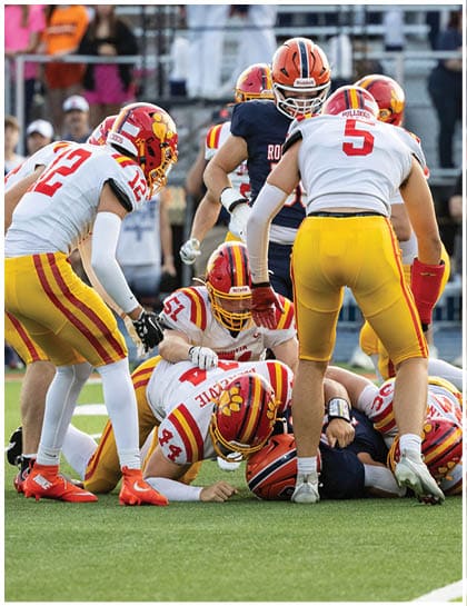 A football player wearing a blue and red jersey. Description generated by AI