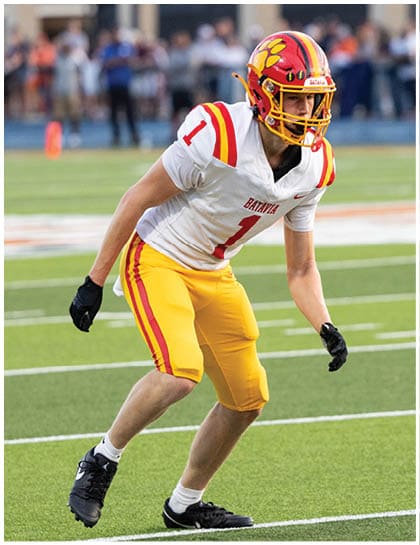 A football player wearing a blue and red jersey. Description generated by AI