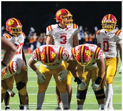 A football game is taking place with a group of men on the field. Description generated by AI