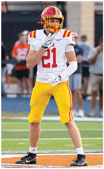 Two football players wearing blue and white uniforms. Description generated by AI