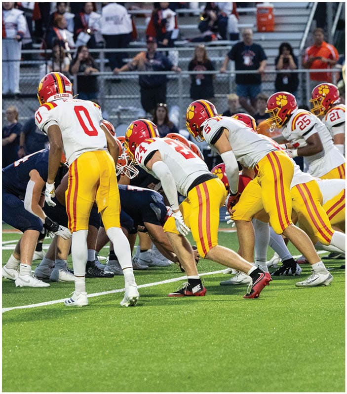 A group of football players on a field. Description generated by AI