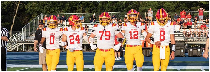 A football game is taking place on a field with players wearing blue and white uniforms. Description generated by AI