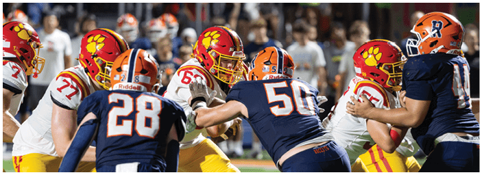 A group of football players on a field. Description generated by AI