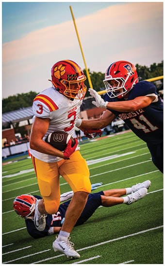 Two football players wearing blue and white uniforms. Description generated by AI