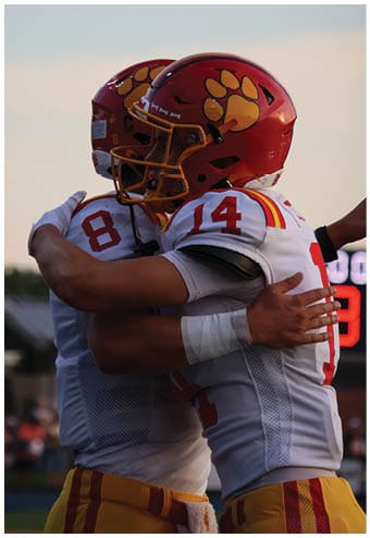 A group of football players celebrating a touchdown. Description generated by AI