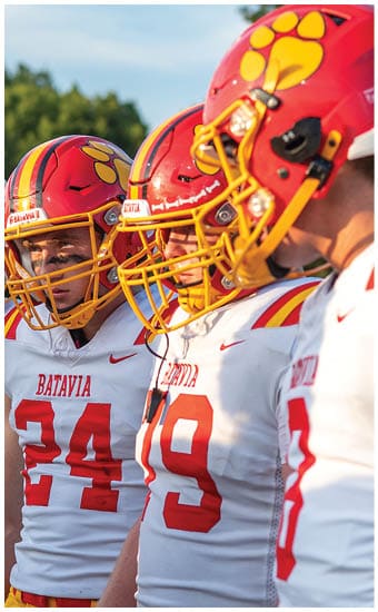 Two football players wearing blue and white uniforms. Description generated by AI
