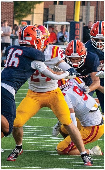 Two football players wearing blue and white uniforms. Description generated by AI