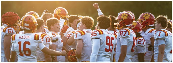 A group of football players on a field. Description generated by AI