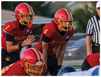 A group of football players on a field. Description generated by AI