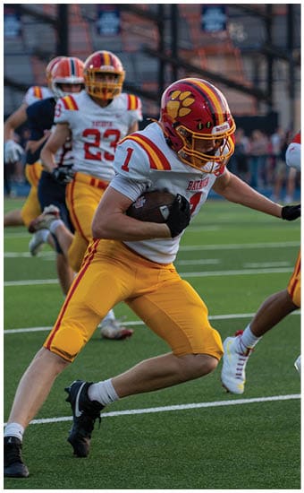 Two football players wearing blue and white uniforms. Description generated by AI