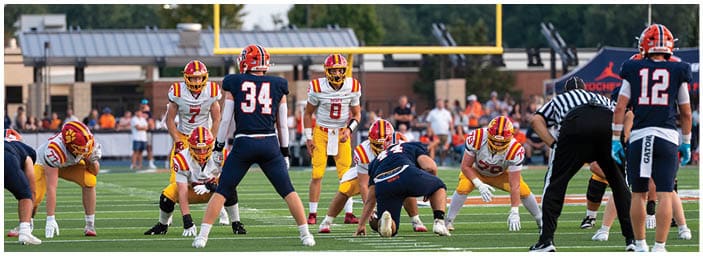 A group of football players on a field. Description generated by AI
