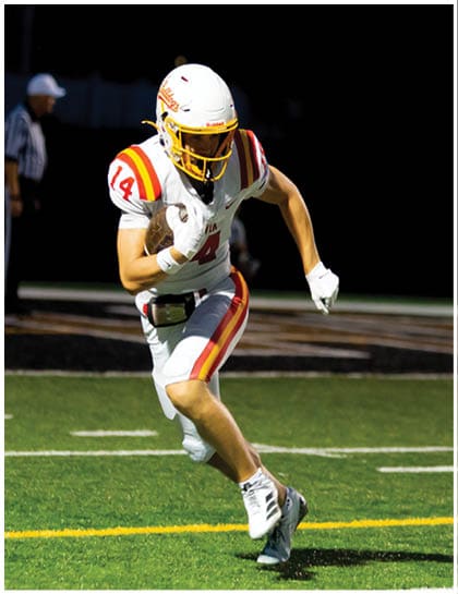 A football player wearing a blue and red jersey. Description generated by AI