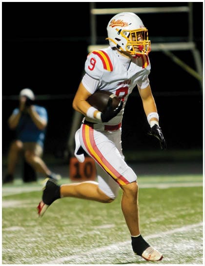 A football player wearing a blue and red jersey. Description generated by AI