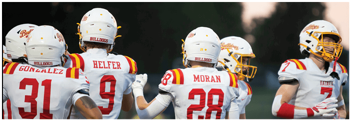 A football game is taking place on a field with players wearing blue and white uniforms. Description generated by AI