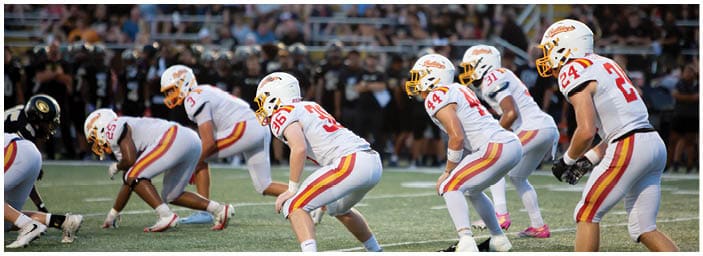 A group of football players on a field. Description generated by AI