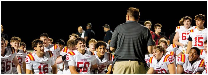 A group of football players on a field. Description generated by AI