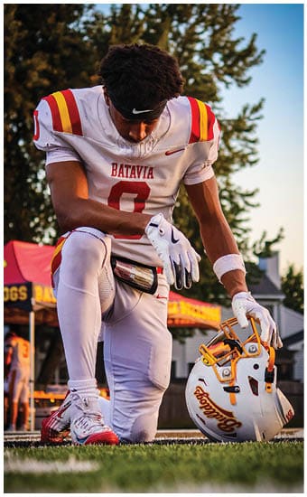 Two football players wearing blue and white uniforms. Description generated by AI