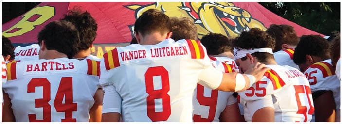 A group of football players on a field. Description generated by AI